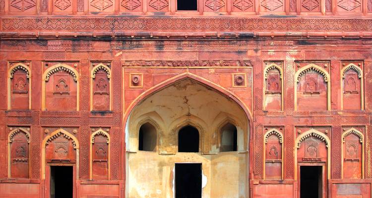 Nahaufnahme einer roten Festungsmauer mit detaillierten Schnitzereien.