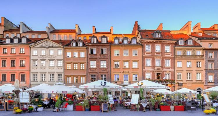 Façades colorées et cafés en plein air dans une place historique.