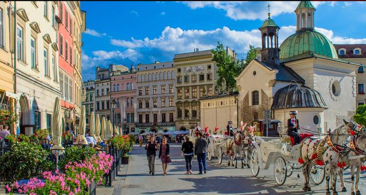 Vue de rue avec des calèches et des gens.