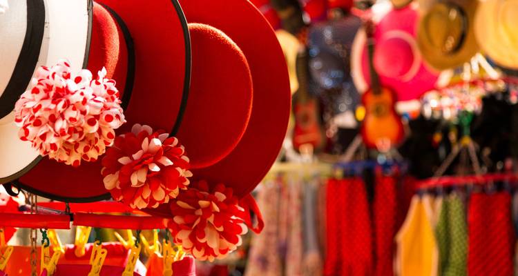 Red hats and red frilly dance dresses at a market.
