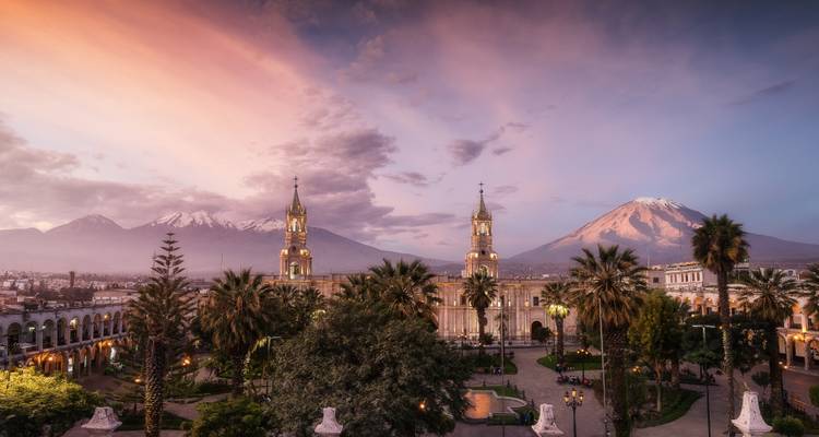 La place principale d'Arequipa avec des volcans en arrière-plan au coucher du soleil.