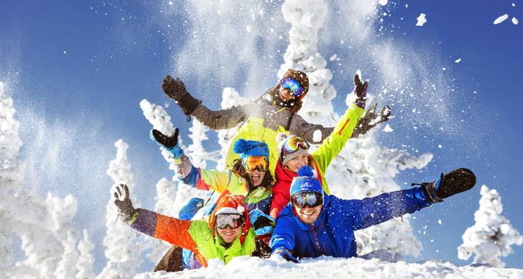 Groupe de personnes portant un équipement de ski coloré dans la neige.