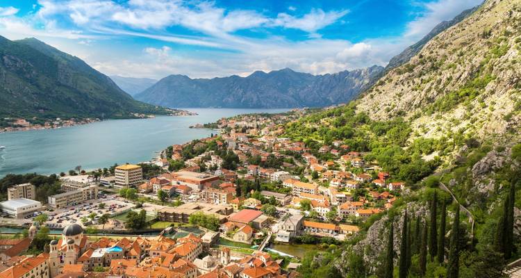 Luchtfoto van een kustplaats omringd door bergen.