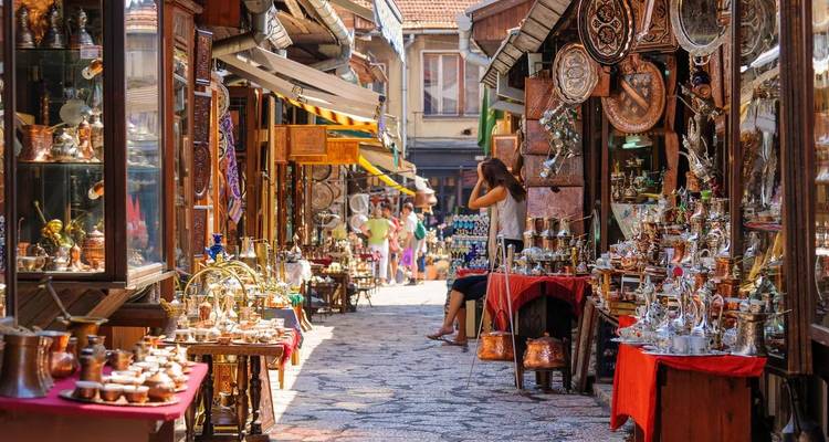 A vibrant market street with various traditional items displayed and people walking.
