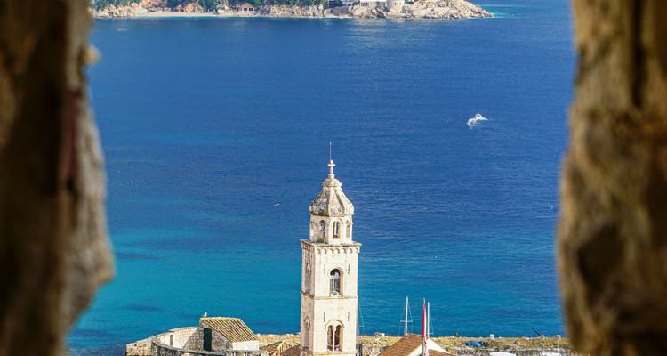 Schilderachtig uitzicht op een kuststadje met een kerktoren aan zee.