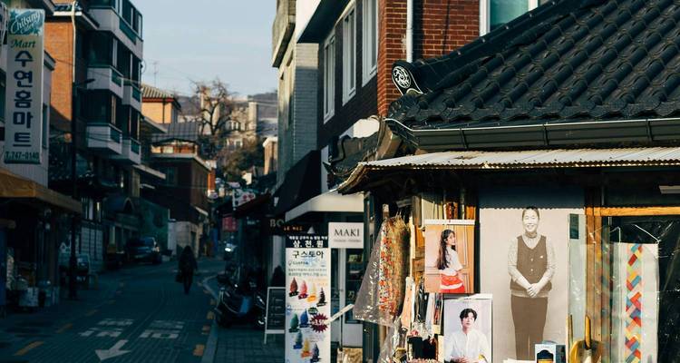 Een straat in een stad met posters en traditionele architectuur.