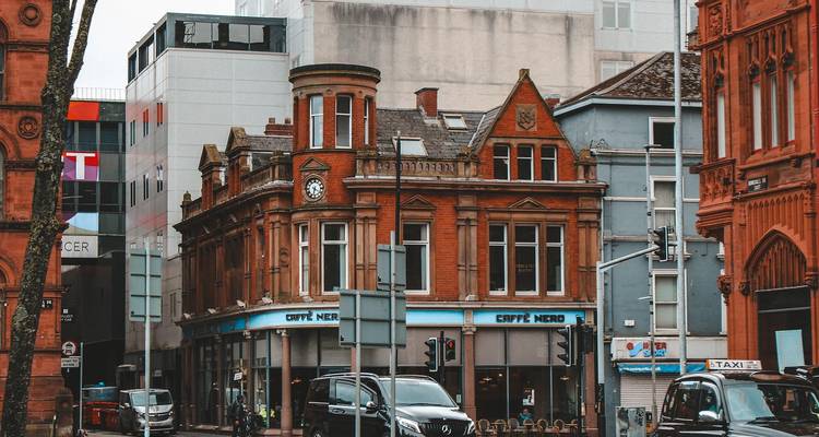 Calle de la ciudad con edificios de ladrillo rojo y tráfico.