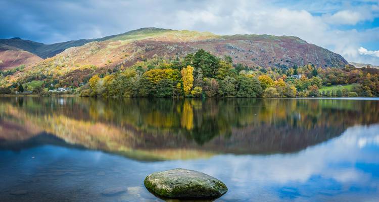 Lake surrounded by mountains with autumn foliage.
