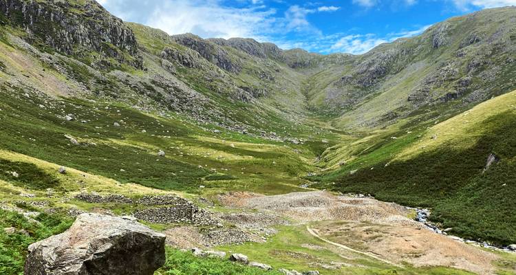Mountain valley with a path and greenery.