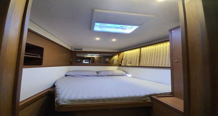 Intérieur d'une cabine de yacht avec un lit soigneusement fait.