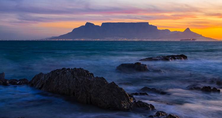 Vue du coucher de soleil sur la montagne de la Table depuis un rivage rocheux.