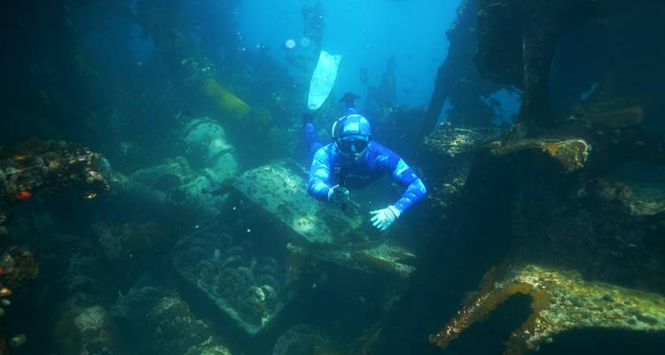 Plongeur explorant une épave sous-marine.