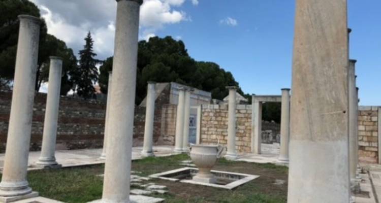 Ancient ruins with standing columns and a large urn
