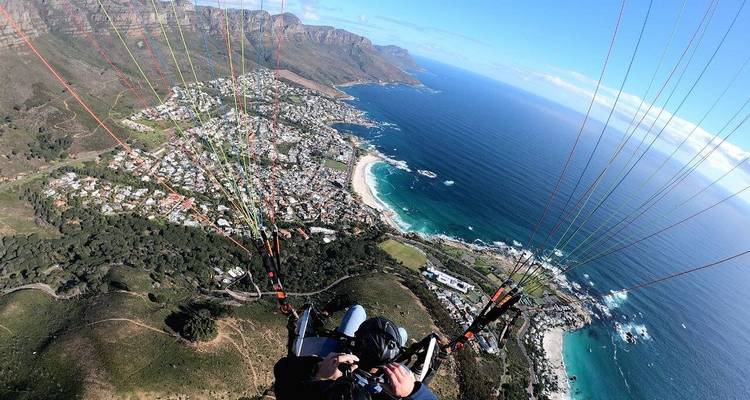 Parapente au-dessus d'un paysage côtier avec collines et océan