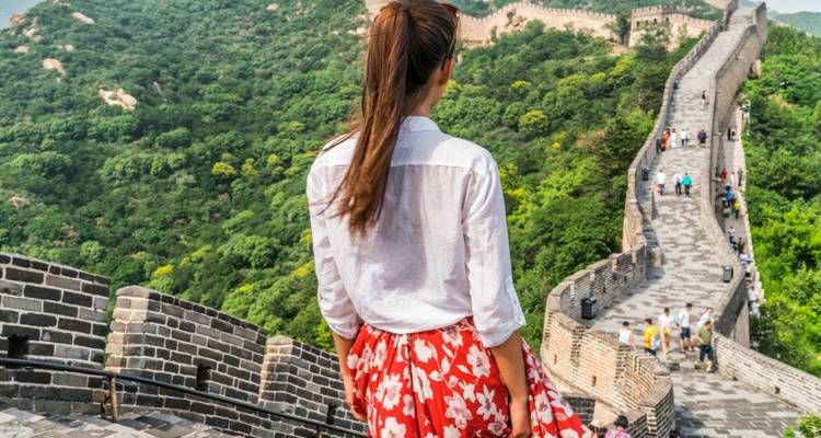 Un touriste admirant la vue le long de la Grande Muraille de Chine s'étendant à travers les montagnes.