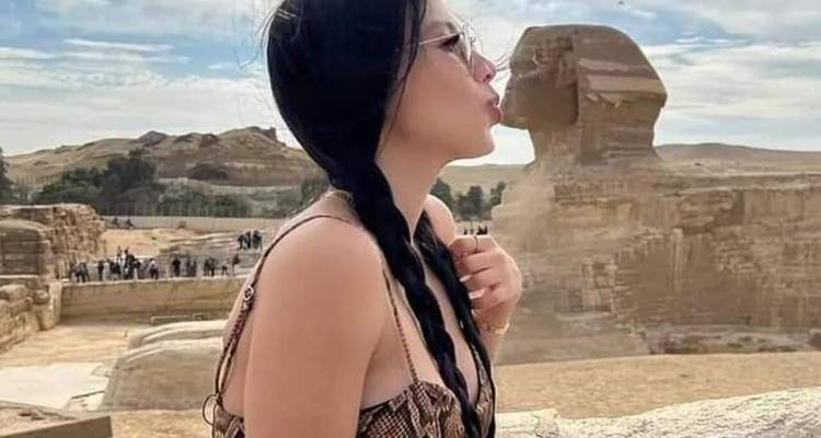 Femme posant près du Sphinx avec un geste espiègle.