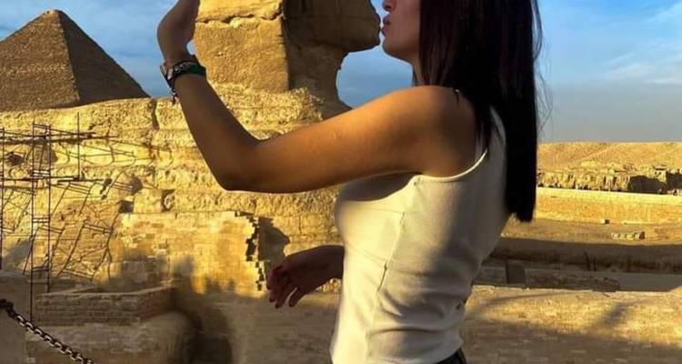 Personne qui pose près du Sphinx avec un geste enjoué.