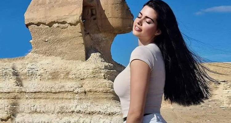 Gros plan d'une personne posant près du Sphinx.