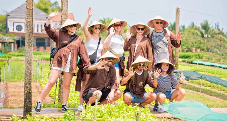Een groep mensen in traditionele kleding die poseren op een groenteboerderij.