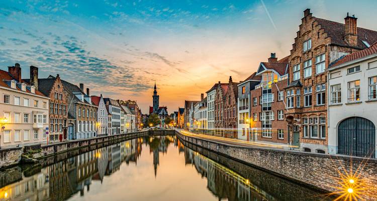 Avondzicht van een gracht omzoomd met gebouwen, Brugge, België.