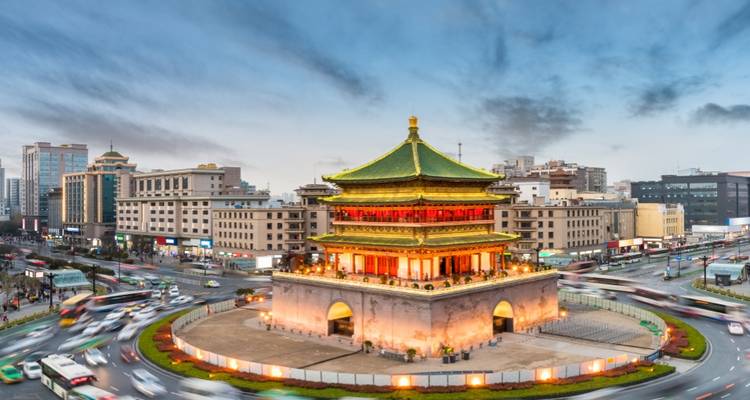 Pagoda histórica en una zona urbana concurrida rodeada de edificios modernos.