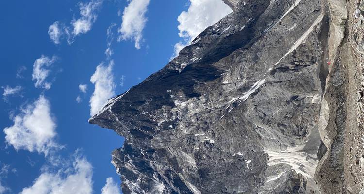 Dramatic rocky mountain peak under a blue sky.