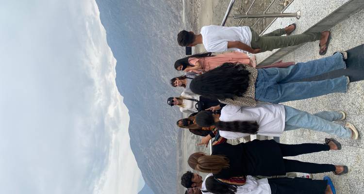 Group of people gathered for a photo with mountains.