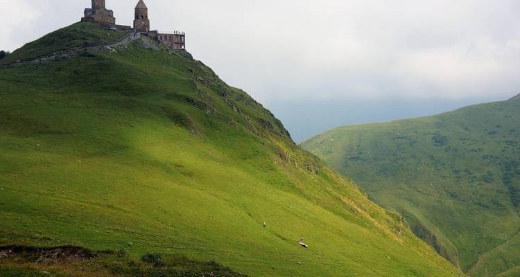 Église au sommet d'une colline surplombant des collines vertes.