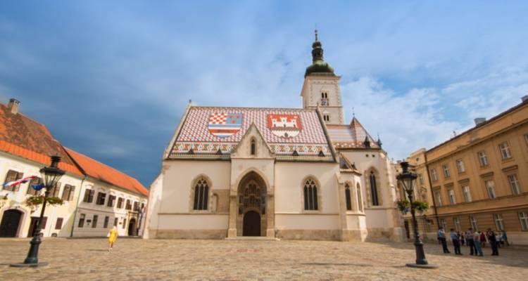 Église Saint-Marc avec des tuiles de toit colorées par une journée ensoleillée.