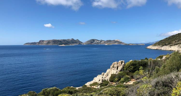 Belle vue sur la mer ouverte avec des îles lointaines sous un ciel bleu dégagé.