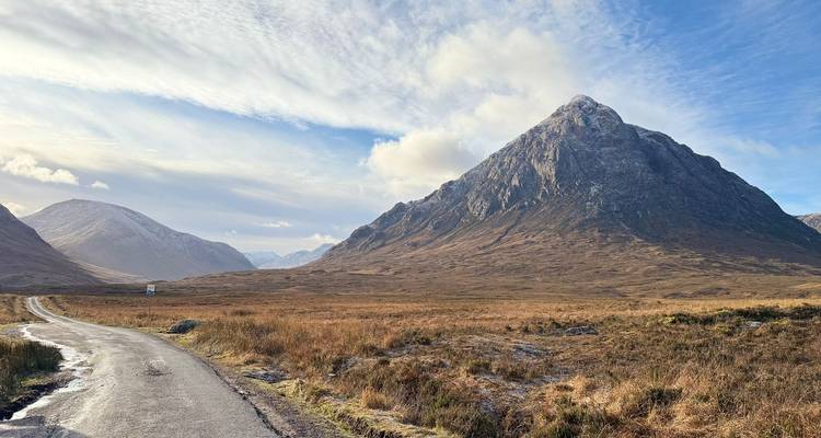 Une vue pittoresque d'un paysage montagneux avec une route sinueuse au premier plan