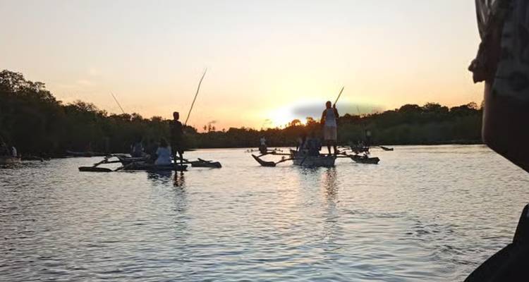 Des groupes de personnes sur des bateaux profitant d'un coucher de soleil sur l'eau