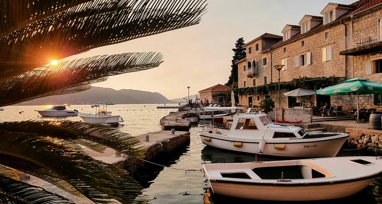 Een schilderachtig uitzicht op een kustdorpje bij zonsondergang met aangemeerde boten