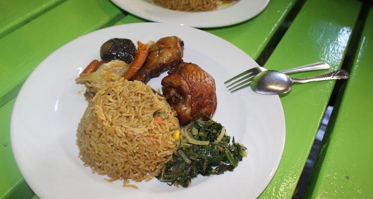 Teller mit gebratenem Reis, Hühnchen und Gemüse auf einem grünen Tisch.