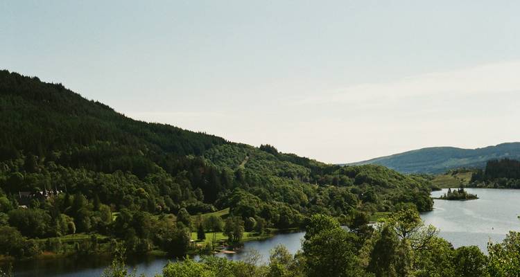 Des collines ondulantes et un lac avec un paysage verdoyant.