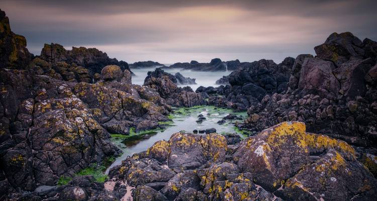 Rotsachtige kust met sfeervolle verlichting.