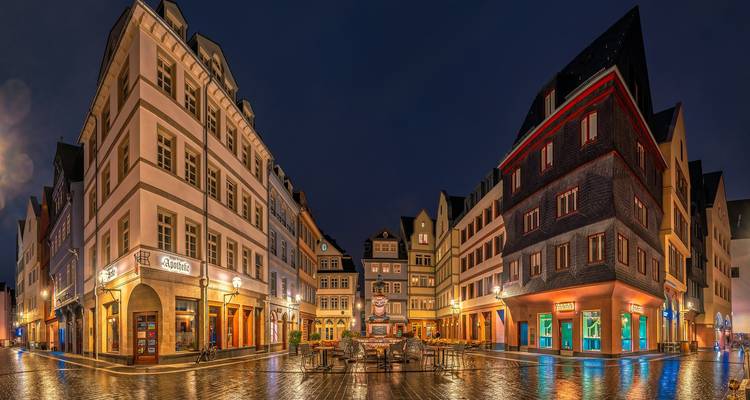 Scène urbaine nocturne, rues pavées mouillées.