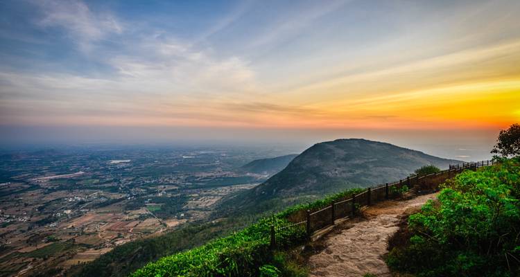 Una vista escénica de un paisaje al atardecer con colinas onduladas y un cielo despejado.