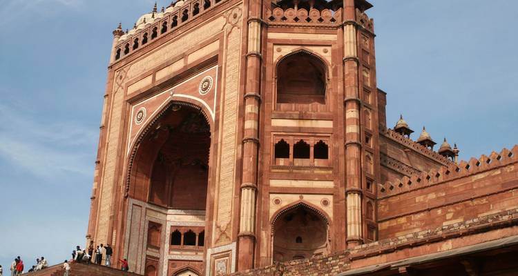 Imposante porte Buland Darwaza en grès rouge massif à Fatehpur Sikri sous un ciel bleu dégagé.