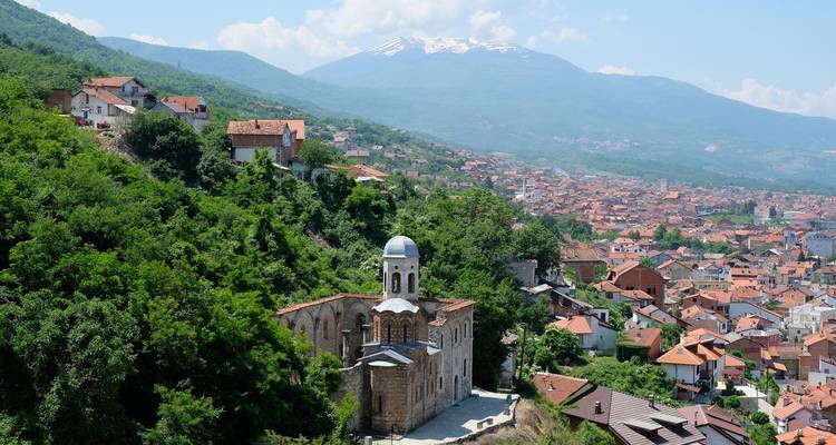 Cityscape with a prominent church and mountain in the background.