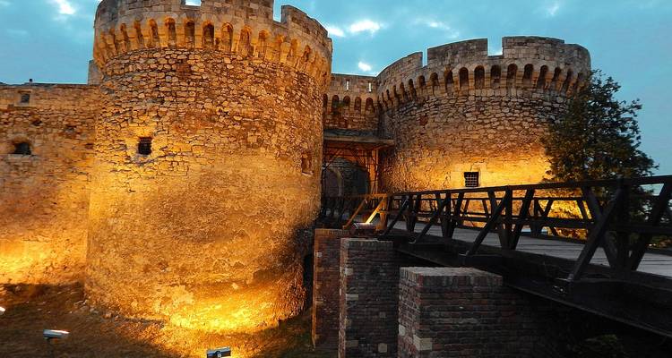 Illuminated stone fortress at night.
