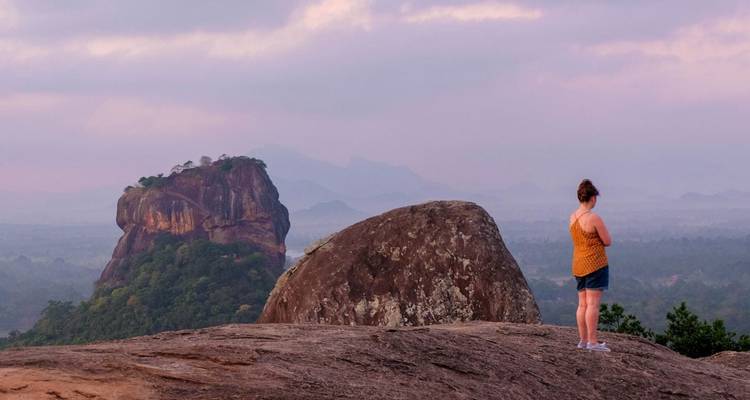 Persoon die naar Sigiriya kijkt vanaf een heuveltop.