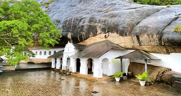 Wit architecturaal complex gebouwd in een rotswand.