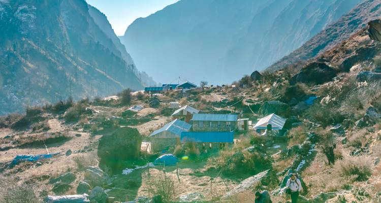 Un petit village dans une vallée de montagne avec des toits bleu vif.
