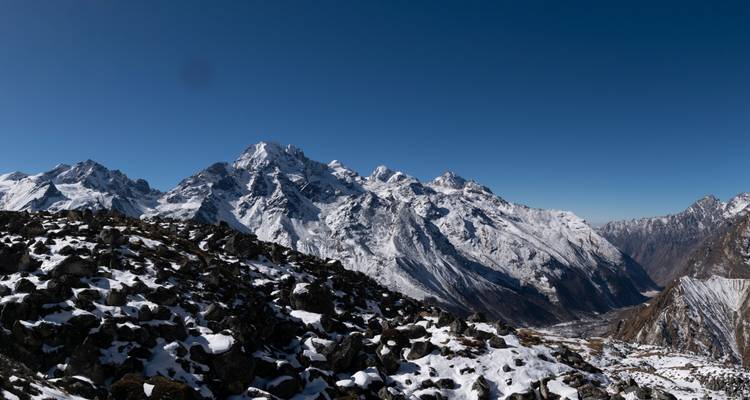 Chaîne de montagnes enneigée sous un ciel bleu dégagé.