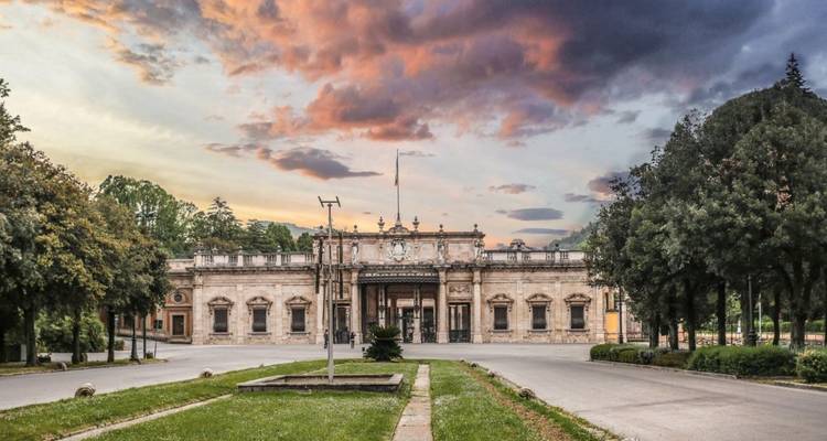 Un bâtiment historique avec un ciel de coucher de soleil et des nuages.