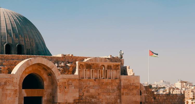 Historisches Gebäude mit einer Kuppel und einer Flagge Jordaniens.