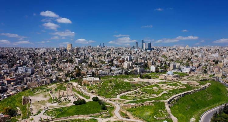 Weite Sicht auf Amman mit antiken Ruinen im Vordergrund.
