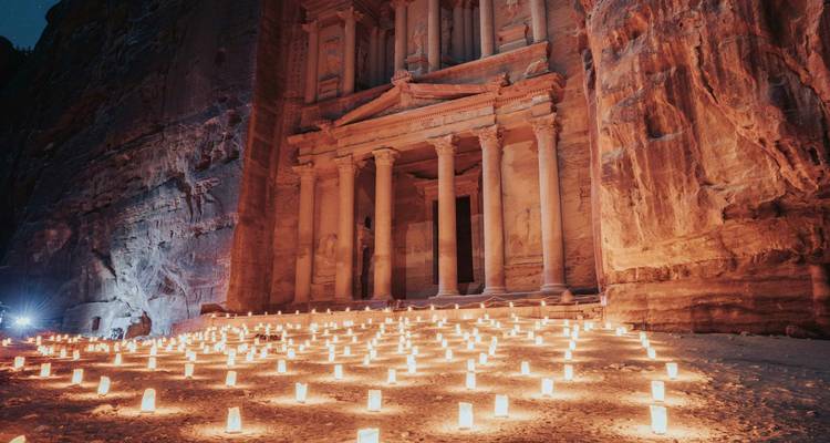Nachtansicht des Al-Khazneh-Tempels in Petra, beleuchtet von Kerzen.