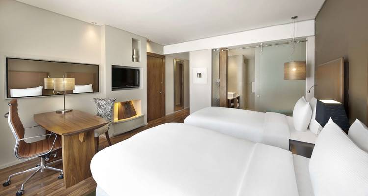 Modernes Hotelzimmer mit zwei Einzelbetten und Schreibtisch